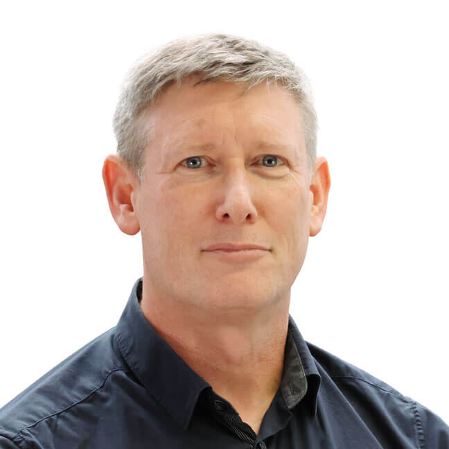 Head shot of a man with short silver hair, and dark blue shirt looking straight at the camera
